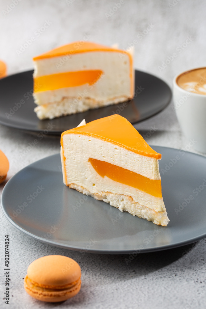 Elegant Cake with coconut, passion fruit, mangoes and bananas, covered with chocolate glaze. Slice of orange layered cake on marble background. Wallpaper for pastry cafe or cafe menu. vertical.