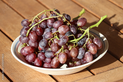Ripe red grapes from Crete / Greece on wooden table, late autumn harvest