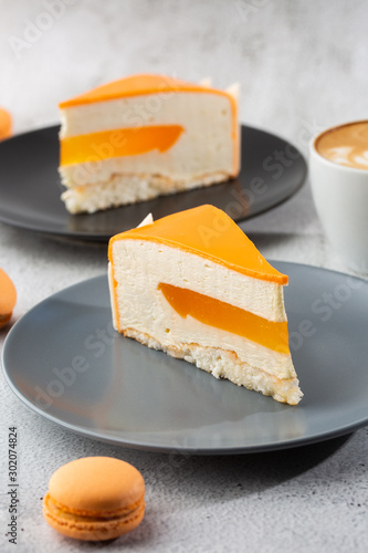 Obraz na płótnie Elegant Cake with coconut, passion fruit, mangoes and bananas, covered with chocolate glaze. Slice of orange layered cake on marble background. Wallpaper for pastry cafe or cafe menu. vertical. w salonie