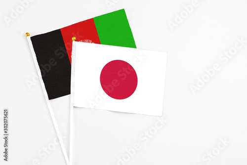Japan and Afghanistan stick flags on white background. High quality fabric, miniature national flag. Peaceful global concept.White floor for copy space. Free Download Japan and Afghanistan stick flags on white background. High quality fabric, miniature national flag. Peaceful global concept.White floor for copy space. - GFXLoad