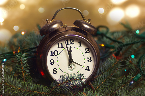 Obraz na plátne Vintage clock approaching midnight time and Christmas lights