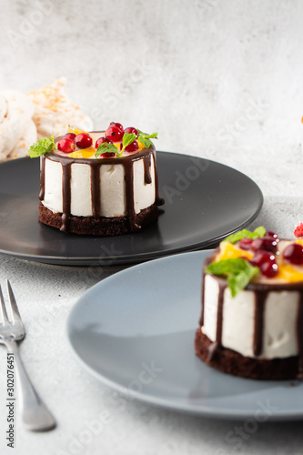 Mini round souffle cake with fruit and chocholate glaze on topc on marble background. Wallpaper for pastry cafe or cafe menu. vertical.