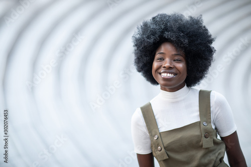 Young and beautiful smiley black girl on a creative urban background, white teeth, inspired face photo