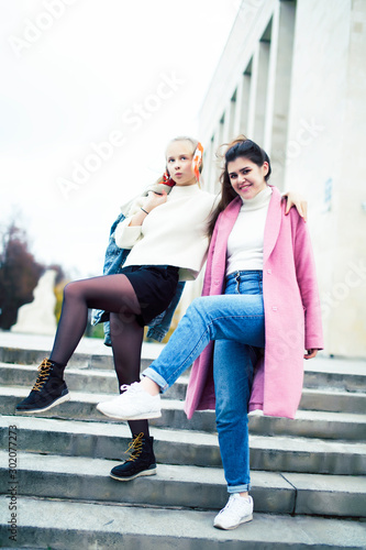 young happy students teenagers at university building on stairs  lifestyle people concept brunette and blond girl