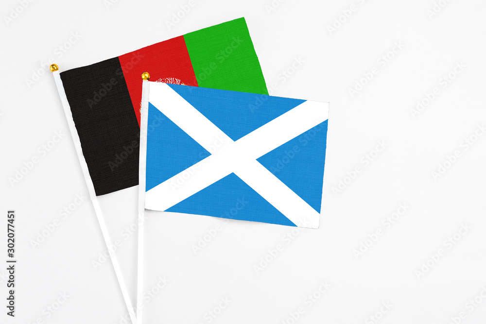 Scotland and Afghanistan stick flags on white background. High quality fabric, miniature national flag. Peaceful global concept.White floor for copy space. Scotland and Afghanistan stick flags on white background. High quality fabric, miniature national flag. Peaceful global concept.White floor for copy space.
