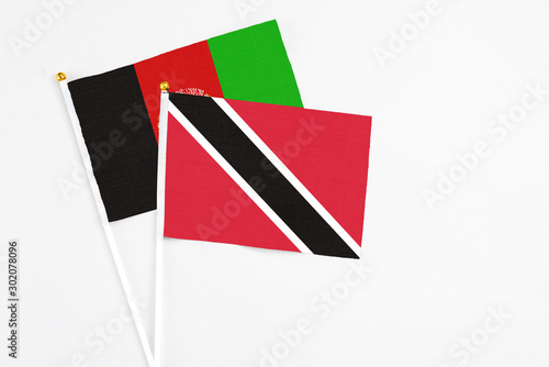 Free Download Trinidad And Tobago and Afghanistan stick flags on white background. High quality fabric, miniature national flag. Peaceful global concept.White floor for copy space. - GFXLoad