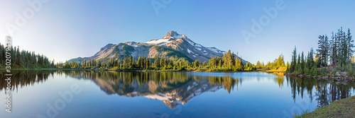 Volcanic mountain in morning light reflected in calm waters of lake.  ©  Tom Fenske