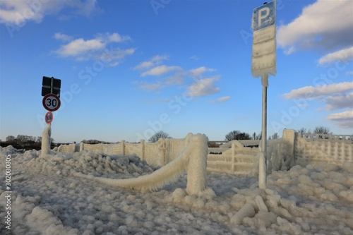 Fototapeta Naklejka Na Ścianę i Meble -  frozen fence and road signs in winter