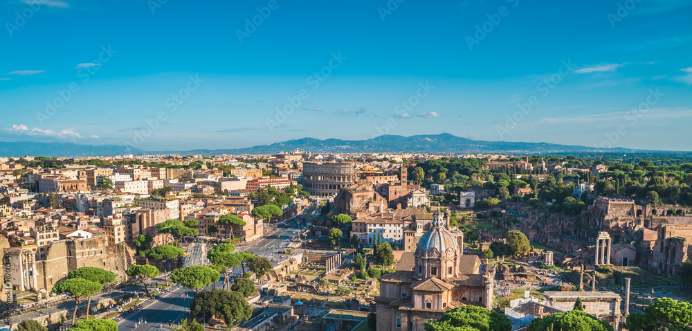 Aerial panorama of Colosseum and Roman Forum in Rome city, Italy. Beautiful cityscape with old famous landmark ruins and historic center of Rome, view from above.