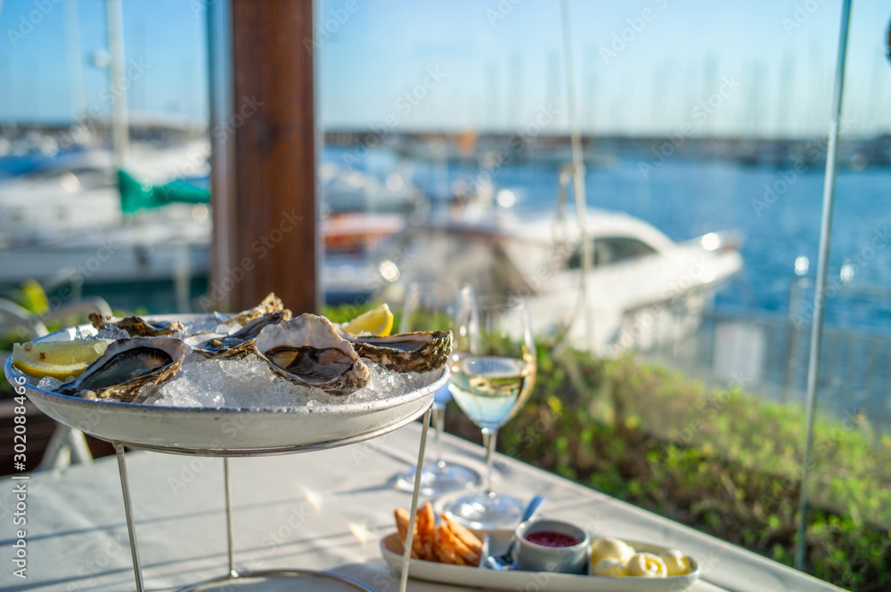 Fototapeta premium dish with oysters on a table in a restaurant with sea view