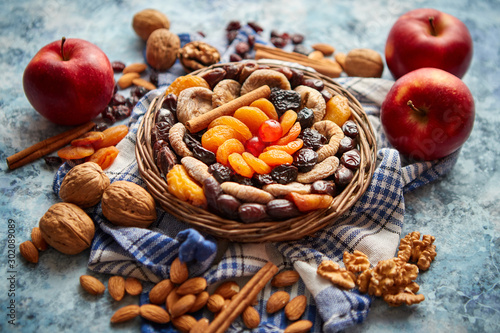 Composition of dried fruits and nuts in small wicker bowl placed on stone table