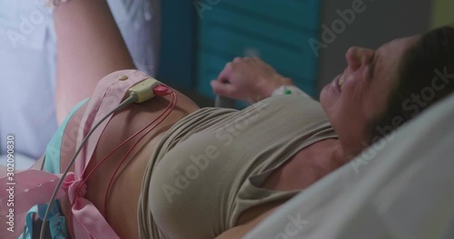 Authentic shot of an young pregnant woman is giving a birth to her future baby in a delivery room of a hospital.