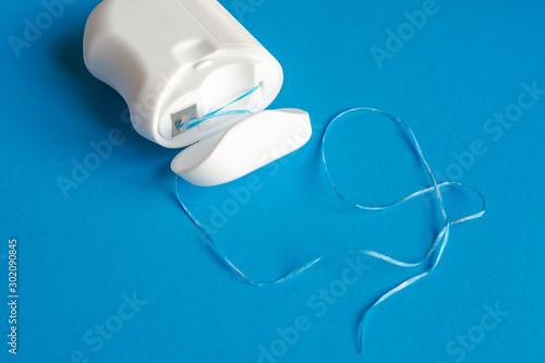 dental floss on a blue background, the concept of care for the oral cavity, preventing tooth decay, copyspace