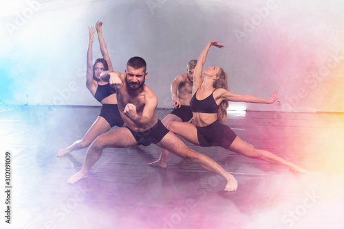 Young modern dancers dancing in the studio. Sport, dancing and urban culture concept. Group of young dancers performing on the stage. Effective performance. beautiful dance.