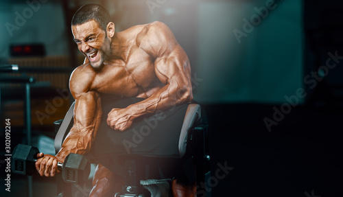Photography Hard Core Bodybuilding. Handsome Bodybuilder Workout at the Gym