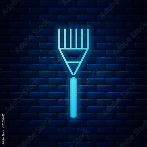 Glowing neon Garden rake icon isolated on brick wall background. Tool for horticulture, agriculture, farming. Ground cultivator. Housekeeping equipment. Vector Illustration