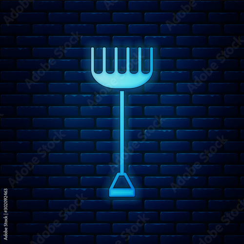 Glowing neon Garden rake icon isolated on brick wall background. Tool for horticulture, agriculture, farming. Ground cultivator. Housekeeping equipment. Vector Illustration