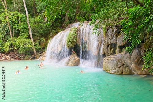 KANCHANABURI, THAILAND - 14 August 2019: tourists enjoying beautiful  Erawan Waterfall.