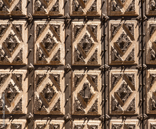 Detail of the solid wood carved door with iron patterns of Convento de San Estaban in Salamanca Spain