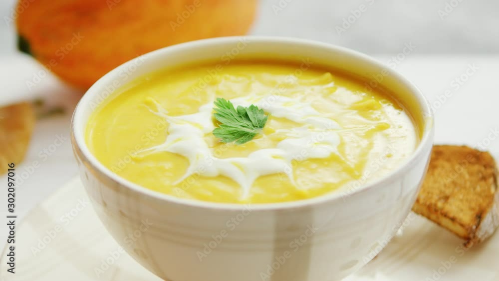 Pumpkin soup in bowl served with bread Pumpkin soup in bowl served with bread