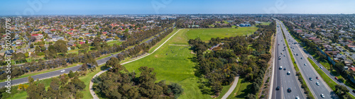 Aerial panoramic landscape of cars driving on highway passing through typical suburban landscape in Melbourne, Australia © Greg Brave