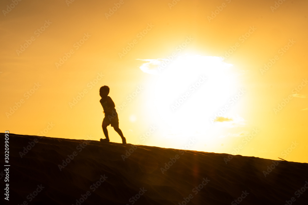 Silueta de niño Corriendo en el Desierto atardecer 