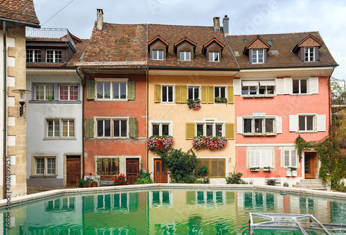 Picturesque old houses reflected in the fountain on a cloudy autumn day. Town of Brugg, Swiss canton of Aargau, Switzerland, Europe. photo