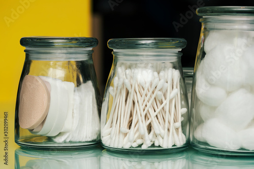 Sterile glass jars to store bathroom accessories like, makeup remover pads, cotton balls, and swabs. photo