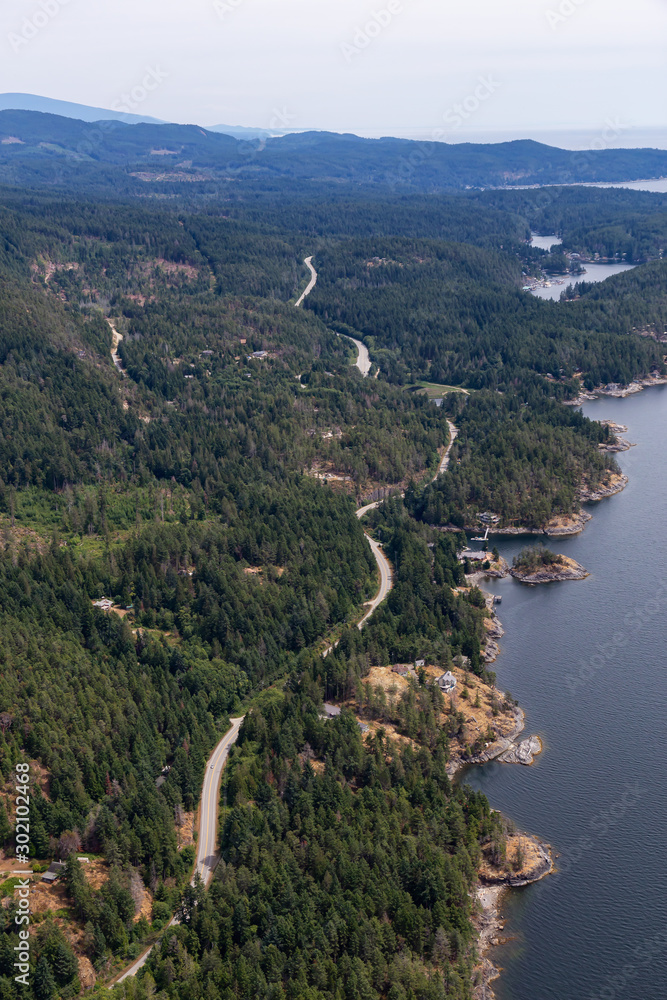 Sunshine Coast, British Columbia, Canada. Aerial View of a windy highway on the coast during a sunny and hazy summer morning.