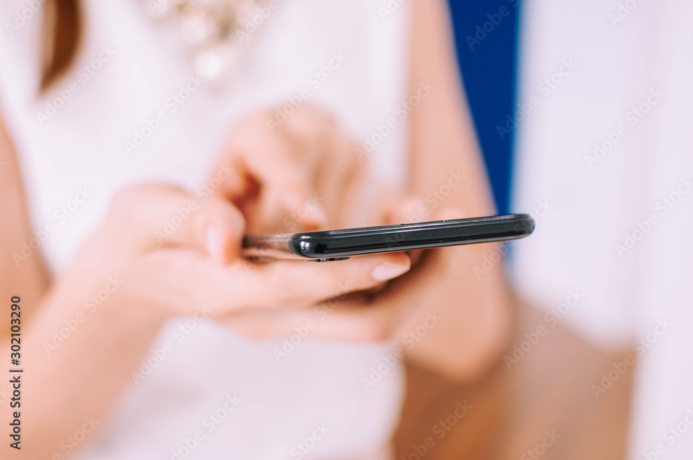 A young woman is using a smartphone indoor A young woman is using a smartphone indoor