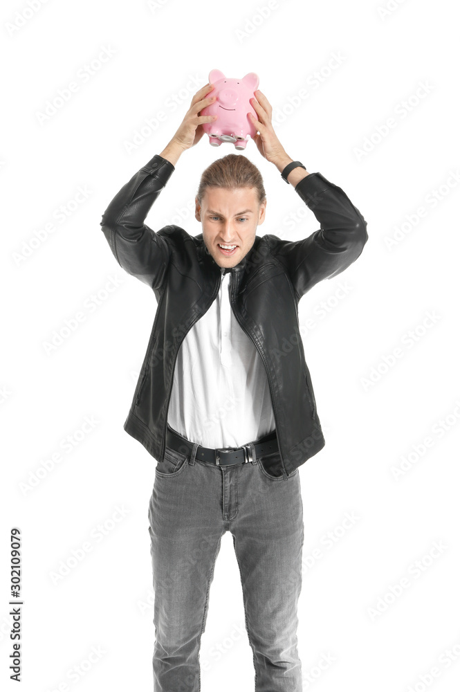 Young man breaking piggy bank on white background Young man breaking piggy bank on white background