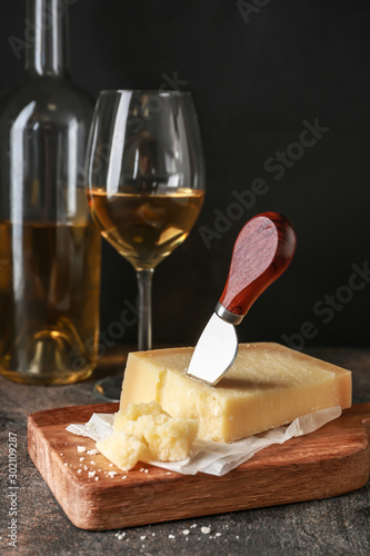 Tasty Parmesan cheese and wine on table