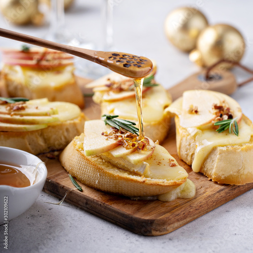 Photo Pear and brie crostini with honey, pecan and rosemary, New Years Eve or Christma