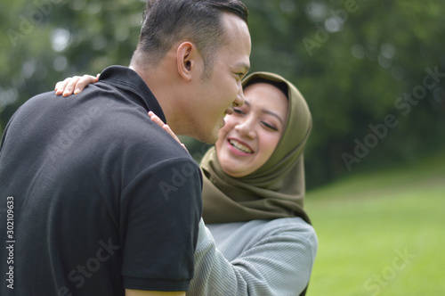 lovely asian Muslim young couple embracing at outdoors