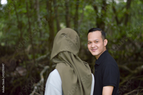Happy young muslim couple on tropical forest with mangrove
