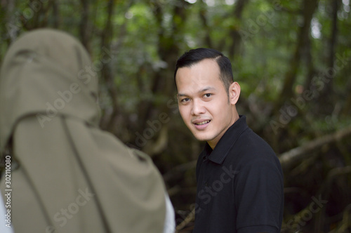 Happy young muslim couple on tropical forest with mangrove