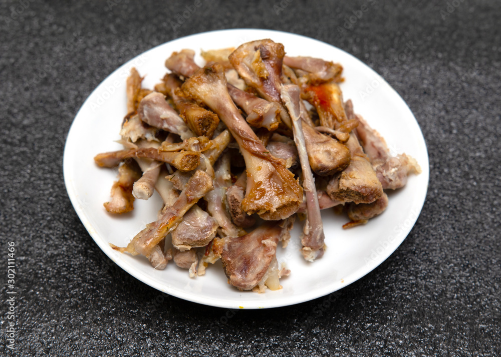 Chicken bones on a plate, after eating. Chicken bones on a plate, after eating.