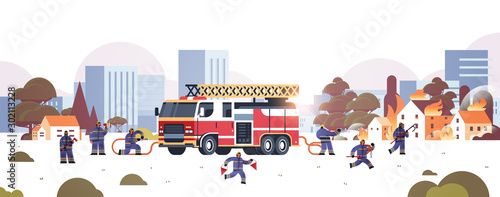 firemen near fire truck getting ready to extinguishing fire firefighters in uniform and helmet firefighting emergency service concept burning houses cityscape background horizontal vector illustration