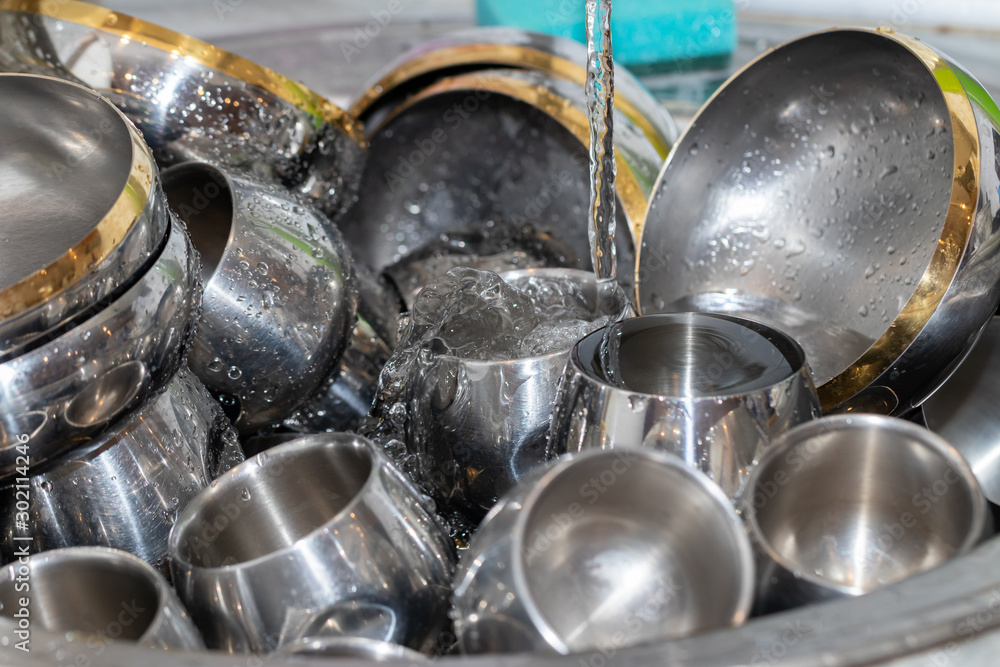 Abstract background. Mountain metal dishes in the sink. Steel bo Abstract background. Mountain metal dishes in the sink. Steel bo