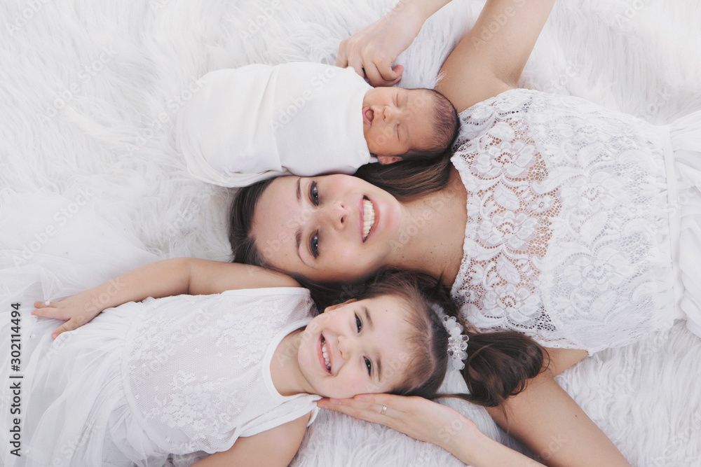 family photo on a white background: woman and boy spend time with children. hug the baby. the concept of childhood, fatherhood, motherhood, IVF family photo on a white background: woman and boy spend time with children. hug the baby. the concept of childhood, fatherhood, motherhood, IVF