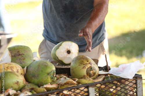 Man chopping green coconut with a machete