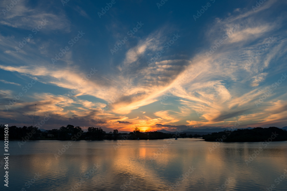 Beautiful sunset sky with colorful clouds over river
