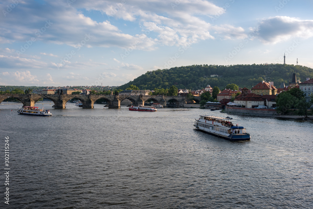 Vltava river with cruise ships and boats and Charles Bridge landmark