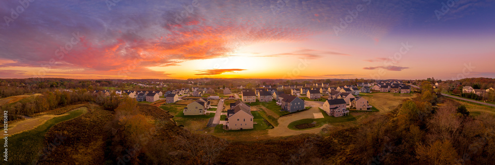 Aerial sunset panorama of luxury real estate development single family house neighborhood street with dramatic sky in Maryland USA Aerial sunset panorama of luxury real estate development single family house neighborhood street with dramatic sky in Maryland USA