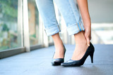 Woman standing on road Catch her foot and she has foot pain. Caused by wearing high heels .Health and beauty concepts