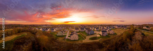 Aerial sunset panorama of luxury real estate development single family house neighborhood street with dramatic sky in Maryland USA