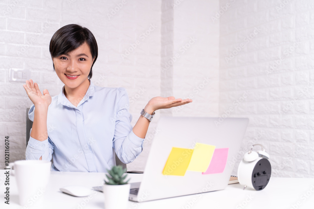 Happy woman sitting at home office and pointing to copy space Happy woman sitting at home office and pointing to copy space