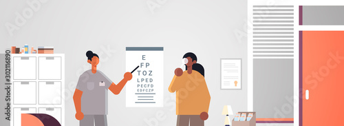 female doctor ophthalmologist pointing at letters on eye chart checking african american patient vision medicine healthcare concept hospital medical clinic office interior portrait horizontal vector