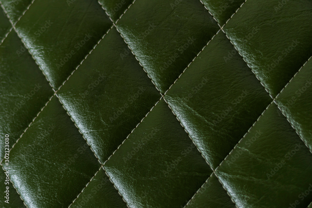Fototapeta premium closeup photo of dark green shiny color leather upholstery furniture have stitches square cool mark for background texture abstract