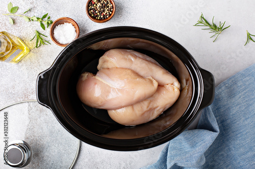Photography Raw chicken breast in a slow cooker ready to be cooked